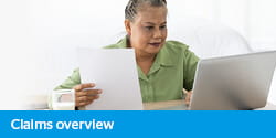 Claims overview elearning - mature lady sitting at her laptop reviewing a document